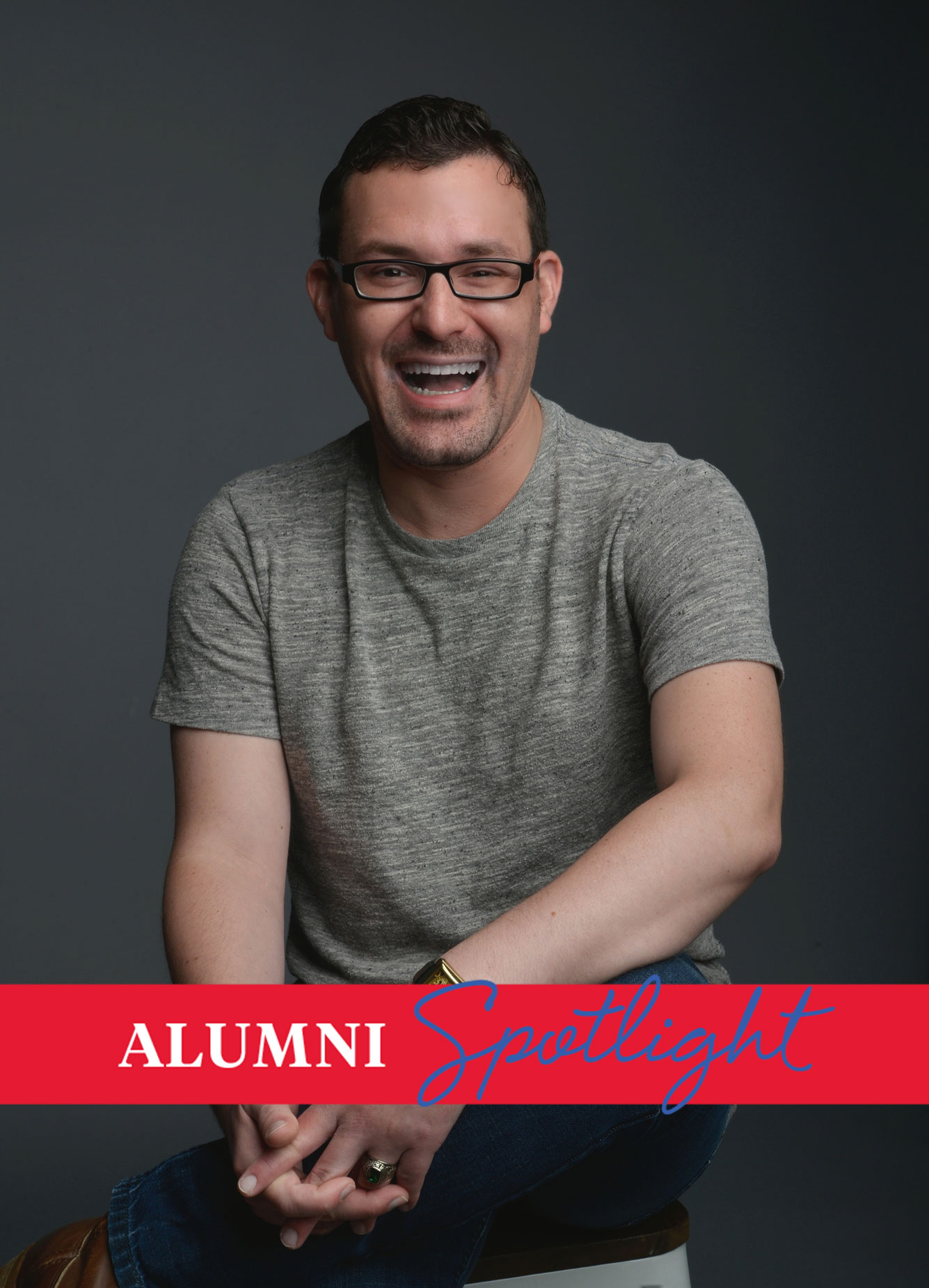 Alum Russell Wyman Jr. poses for a headshot in a gray shirt and black frame glasses.