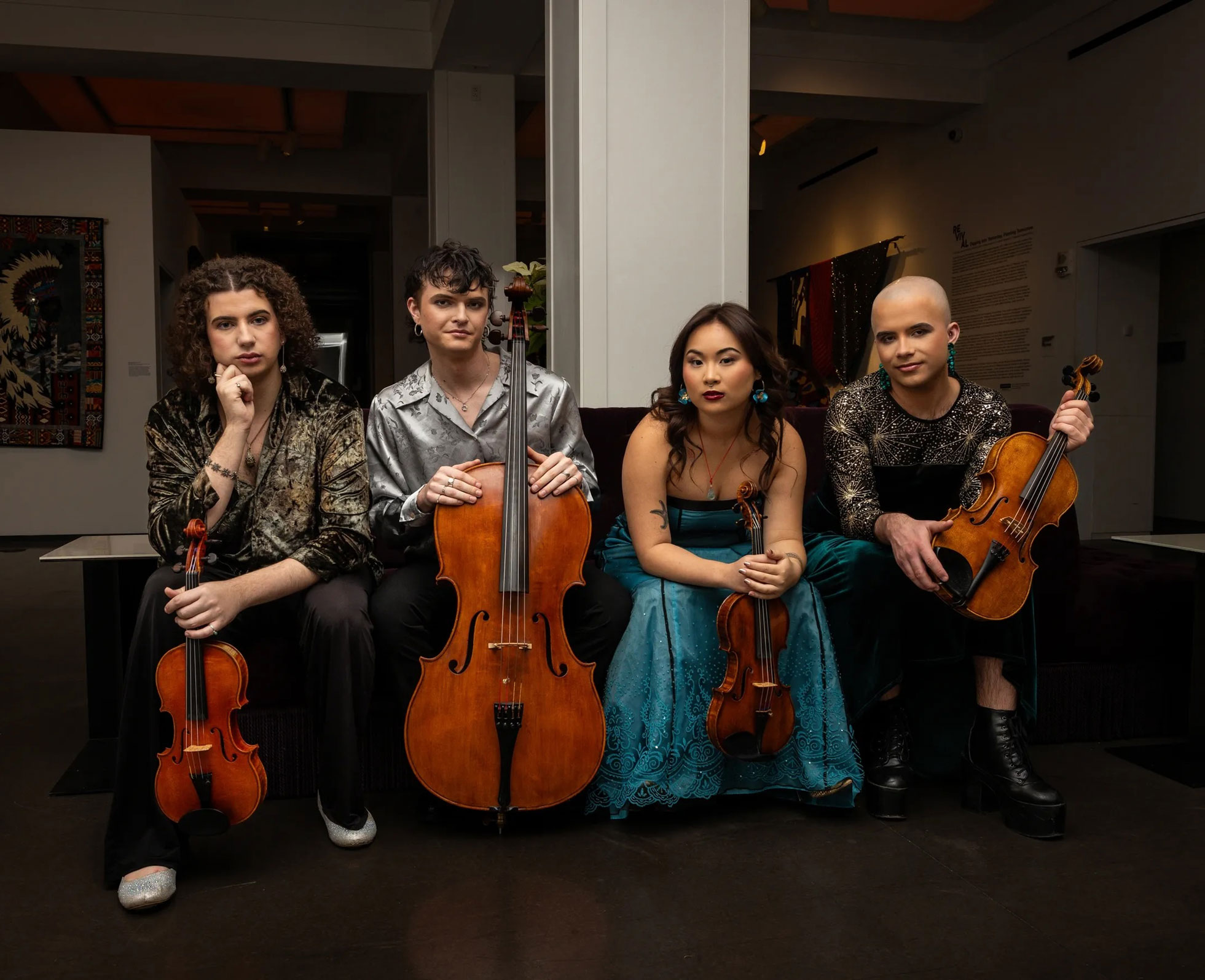 Poiesis Quartet poses with their instruments in an art gallery