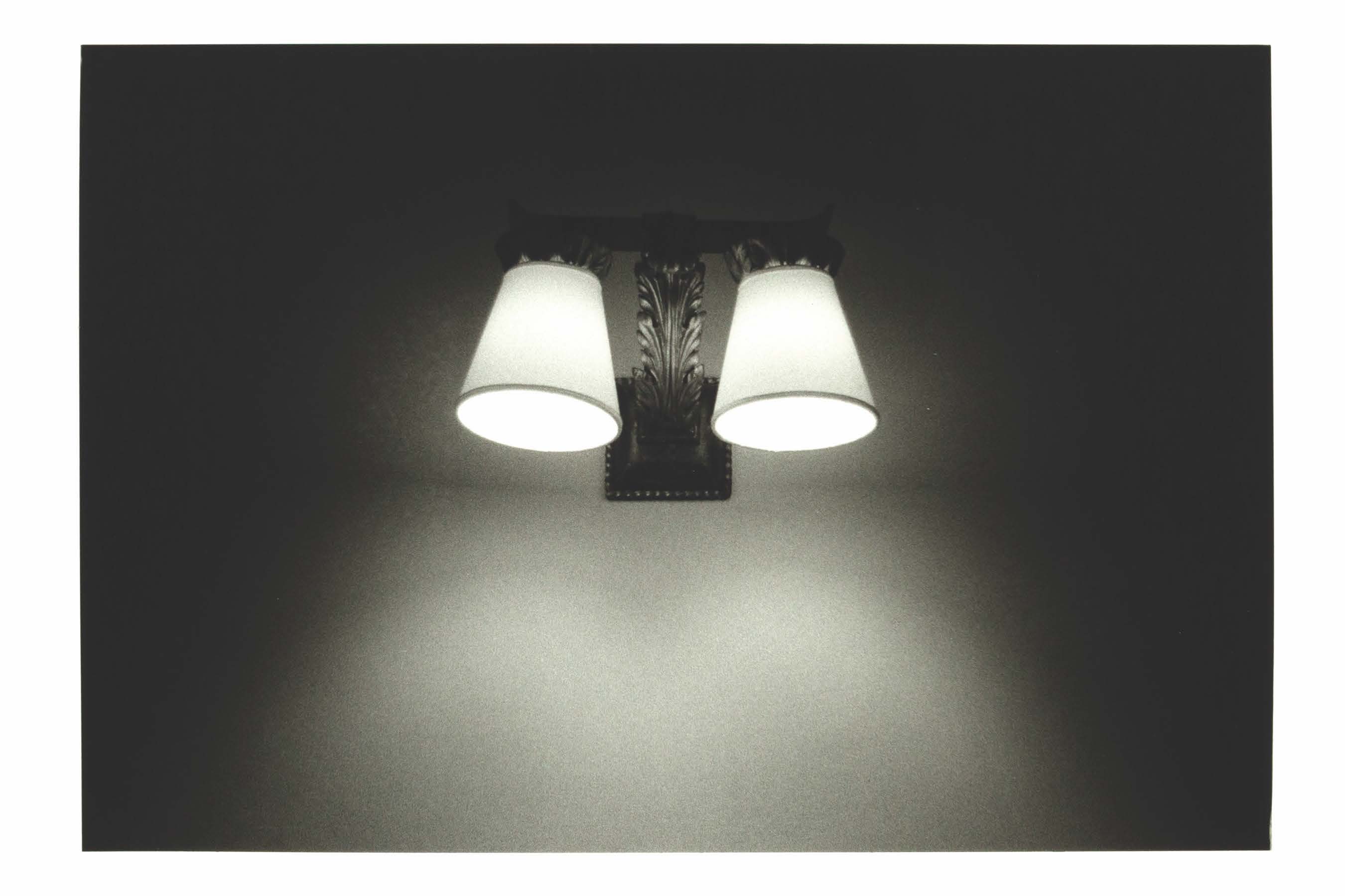 Black and white copperplate photogravure of two sconces on a wall