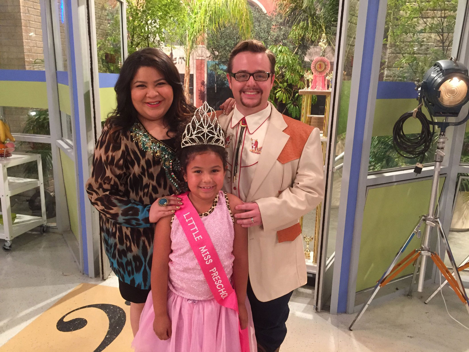 Theatre alum John Paul Green on set with a female actress and child actress