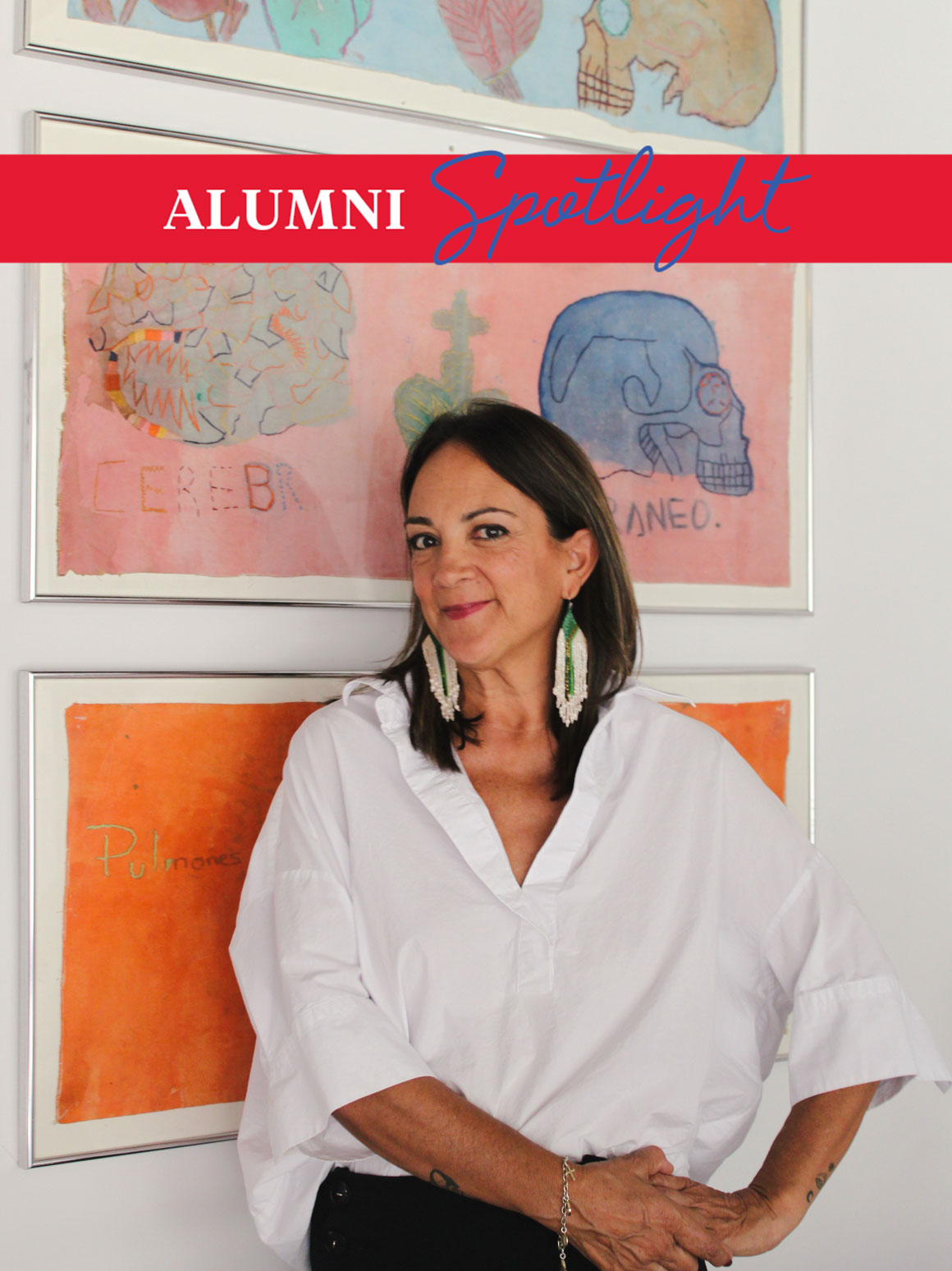 Art history alum Veronica Pesantes poses in front of colorful artwork in a white blouse