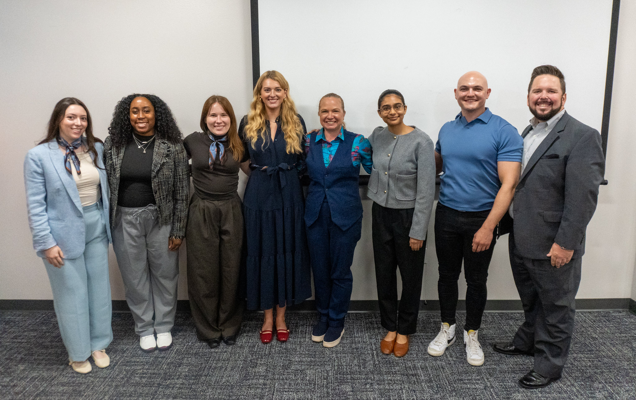 M.A./MBA students and program director Megan Heber pose after presenting their capstone project.