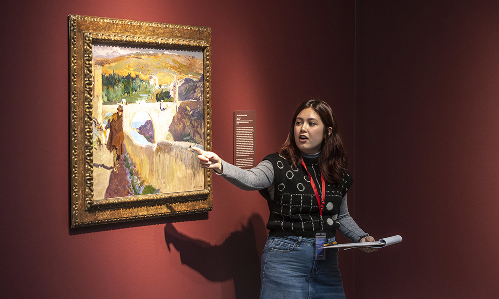 A student in SMU’s Bachelor of Arts in Art History program presents analysis on a painting in a museum.
