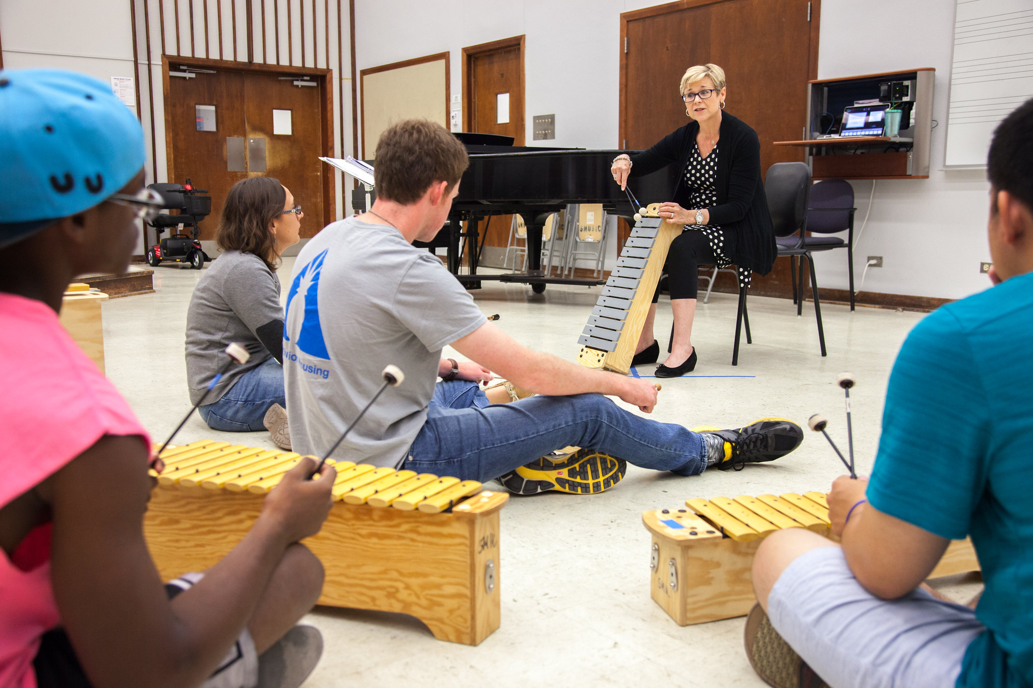 An SMU graduate with a bachelor’s in music education teaches a class of young students in percussion.