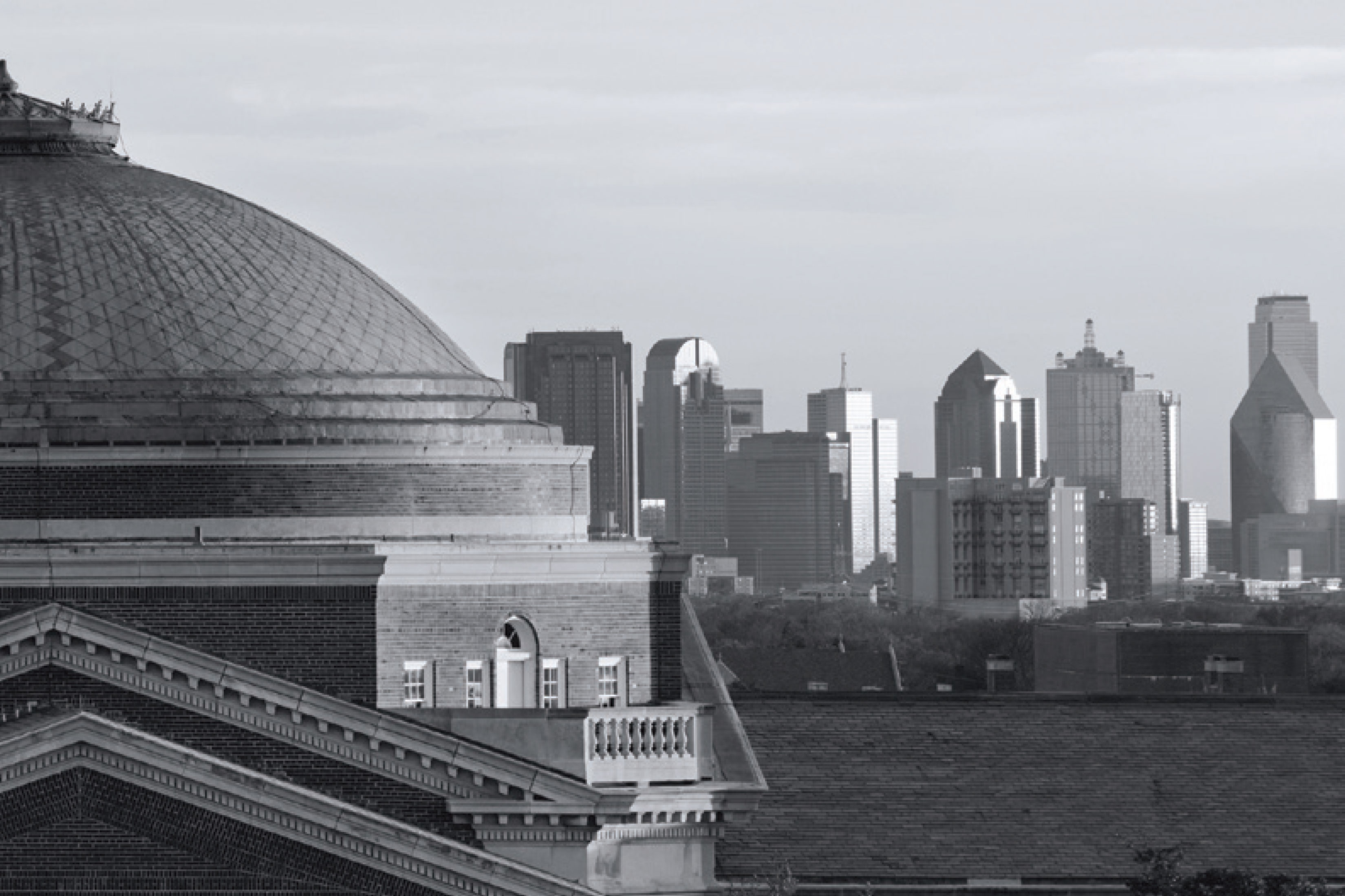 Black and white image of a domed campus building with the Dallas skyline in the background, representing SMU invited seminars.