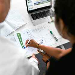 Two people reviewing engineering plans