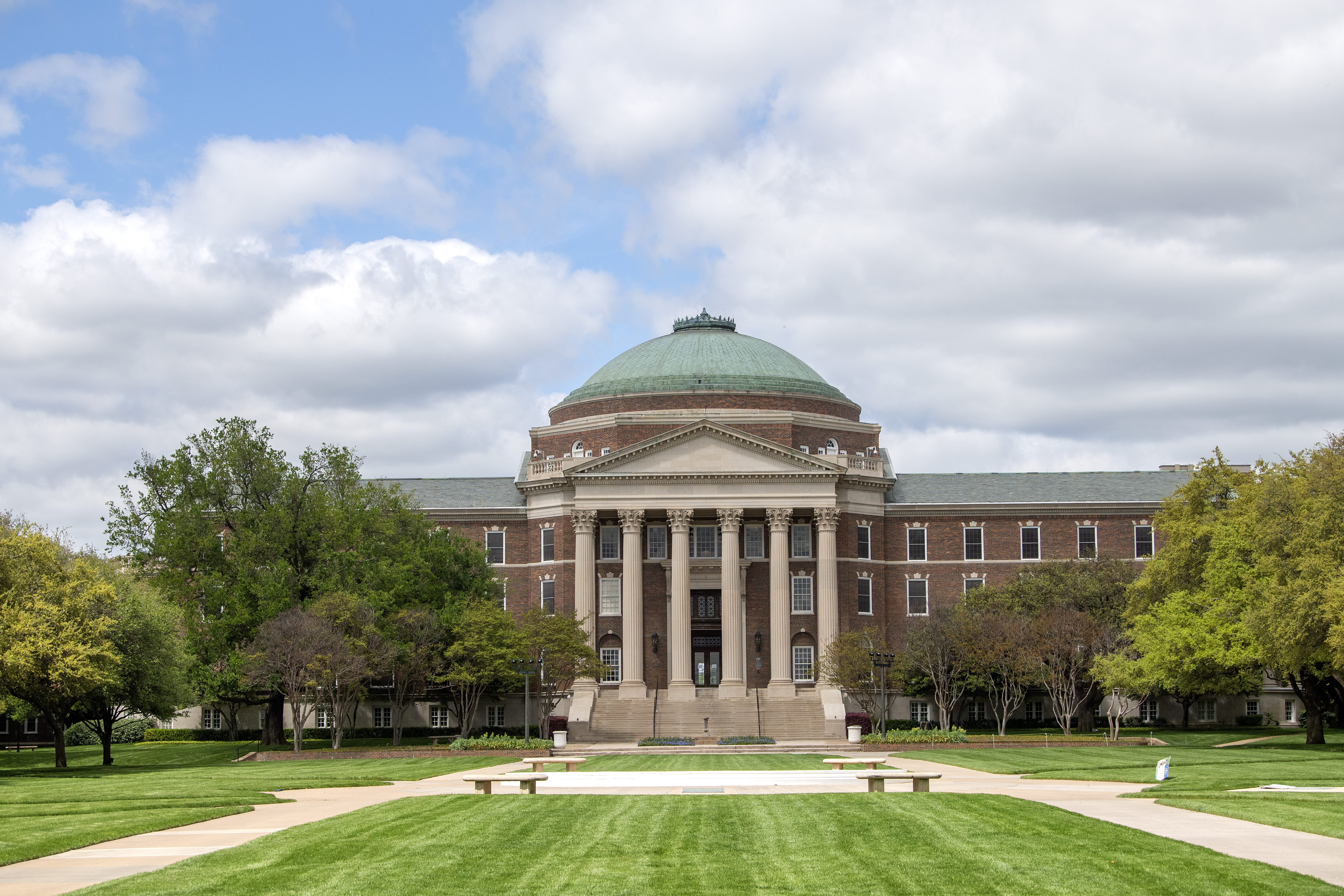 Dallas Hall building, a red brick rotunda building, on a partly cloudy day