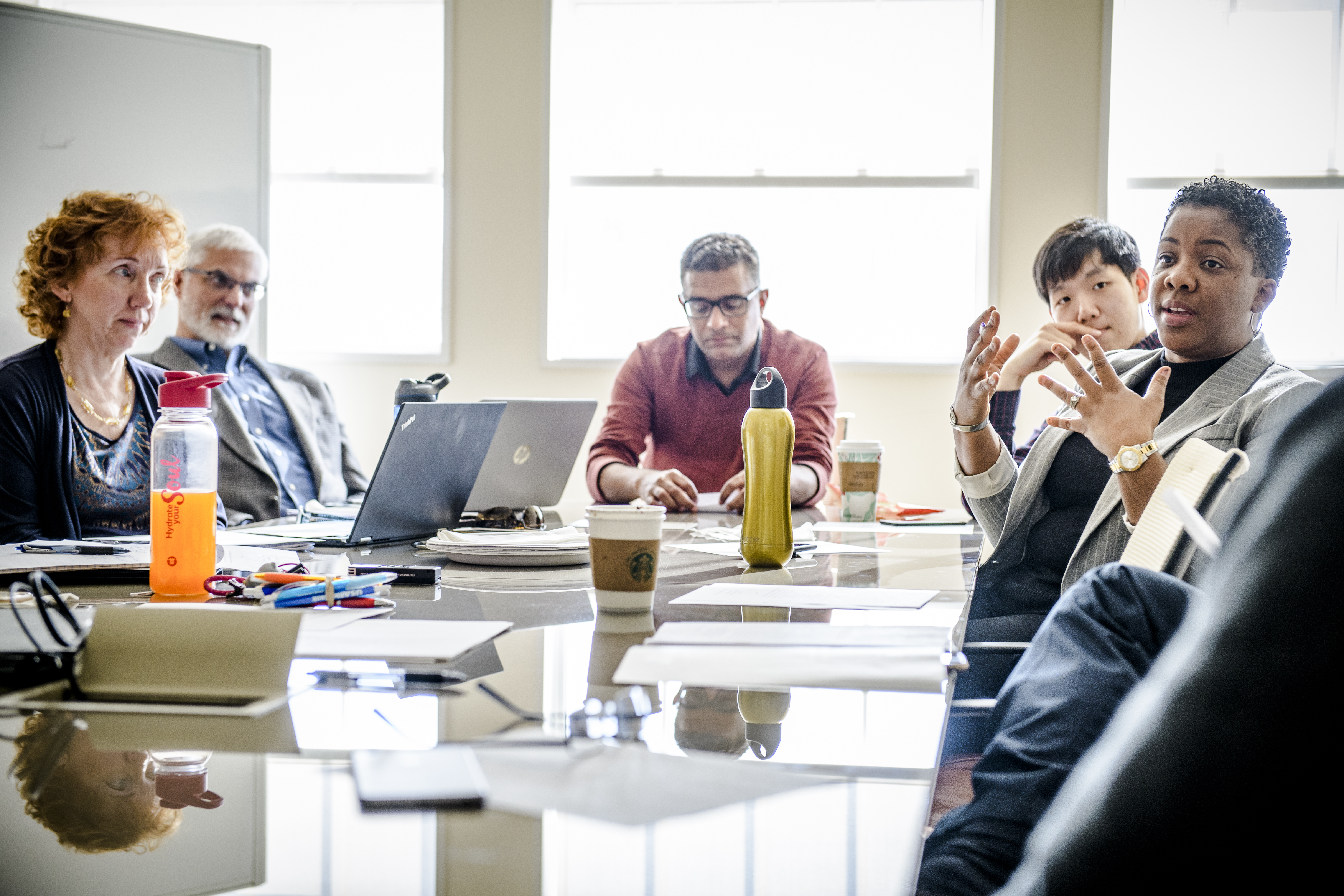 Faculty at conference table holding a meeting