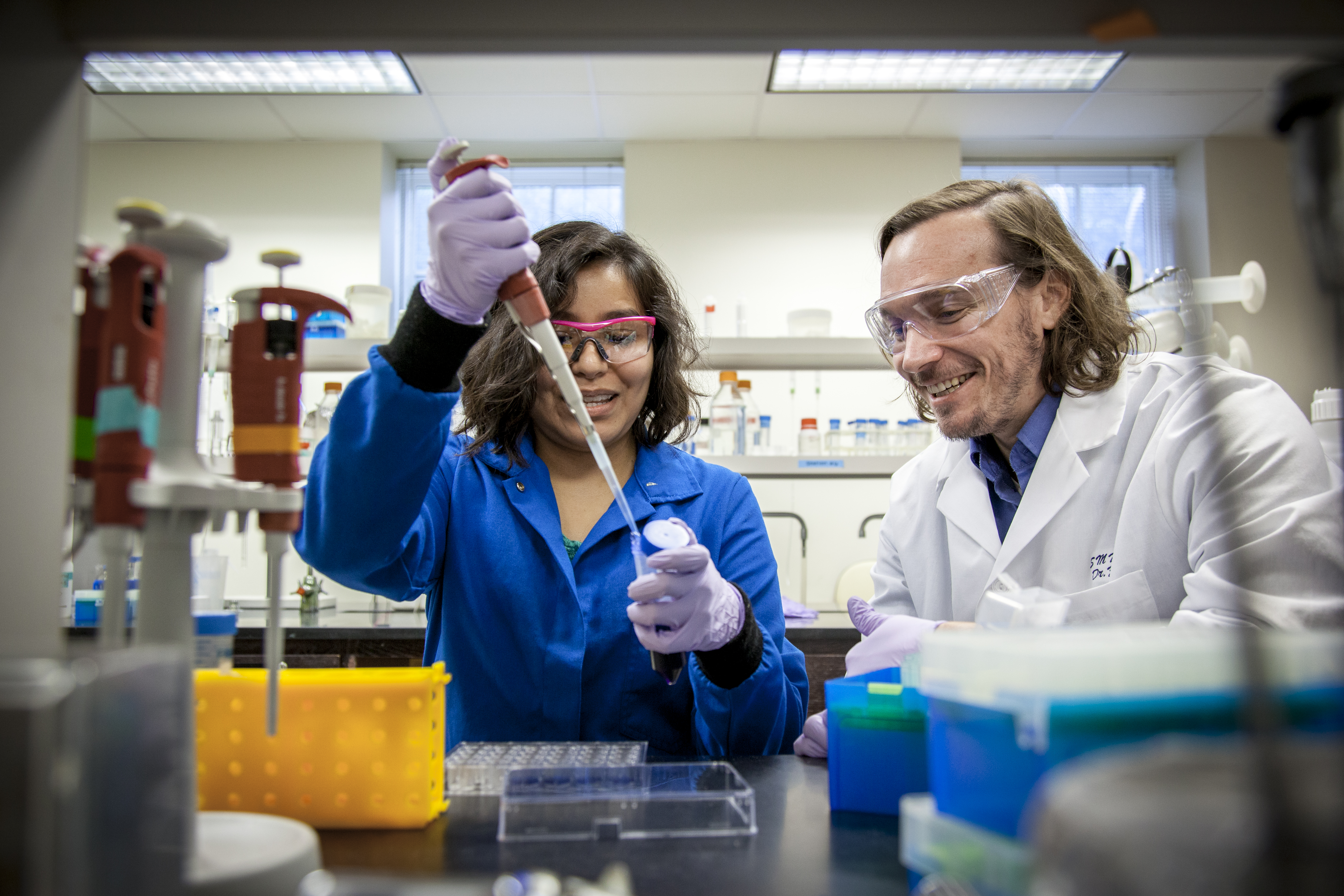 Student and professor working with test tubes in a lab