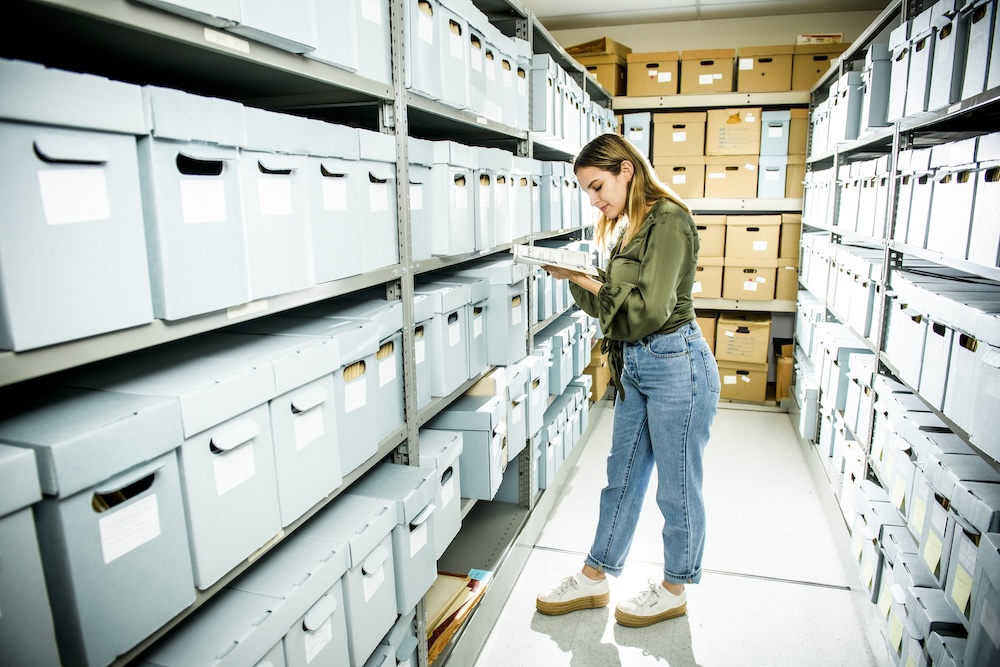 student working in the stacks of an archive