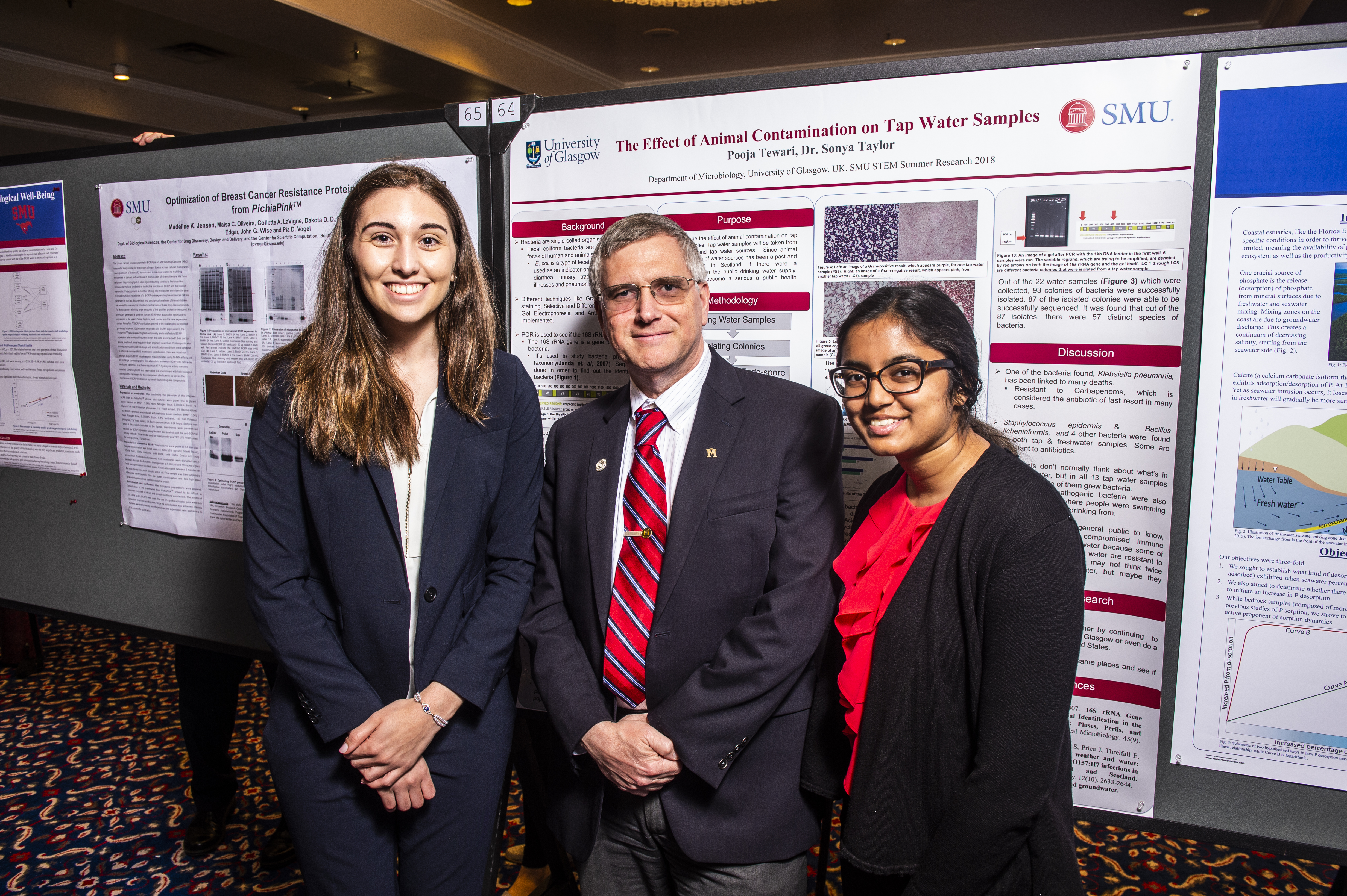 Two students and their faculty advisor standing in front of their research poster