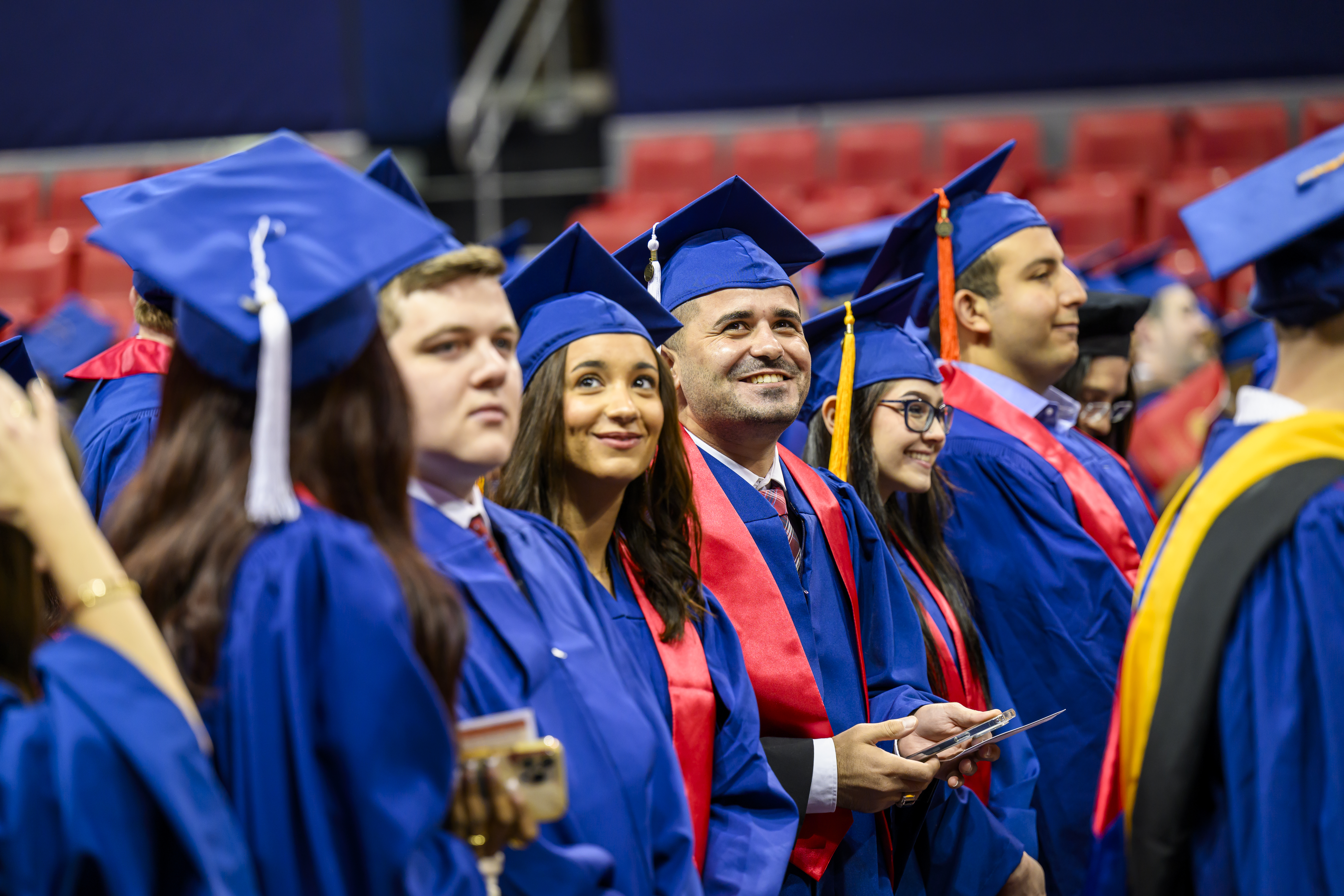 Students smiling and sitting waiting for graduation to start