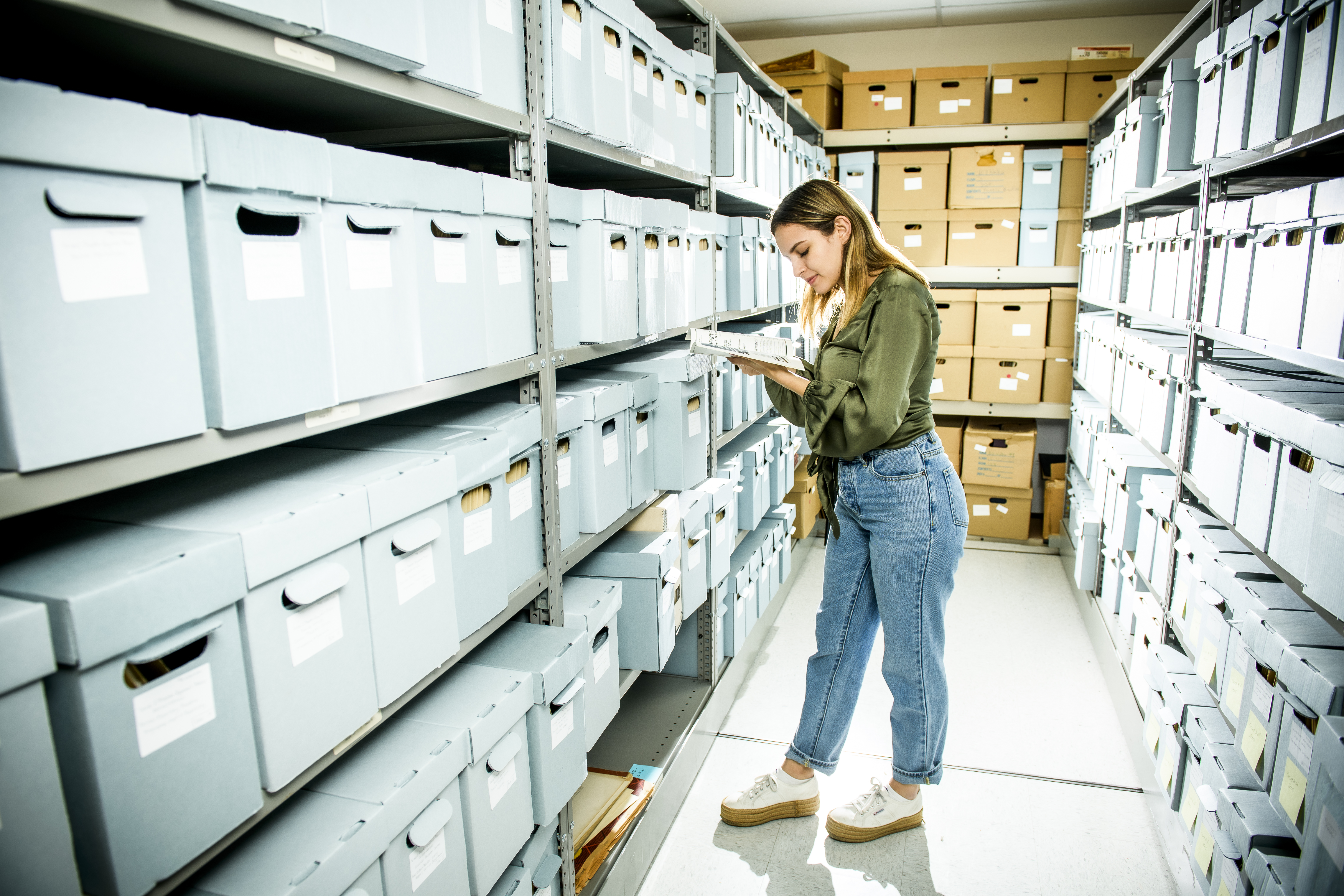 Student looking through archive boxes in storage room