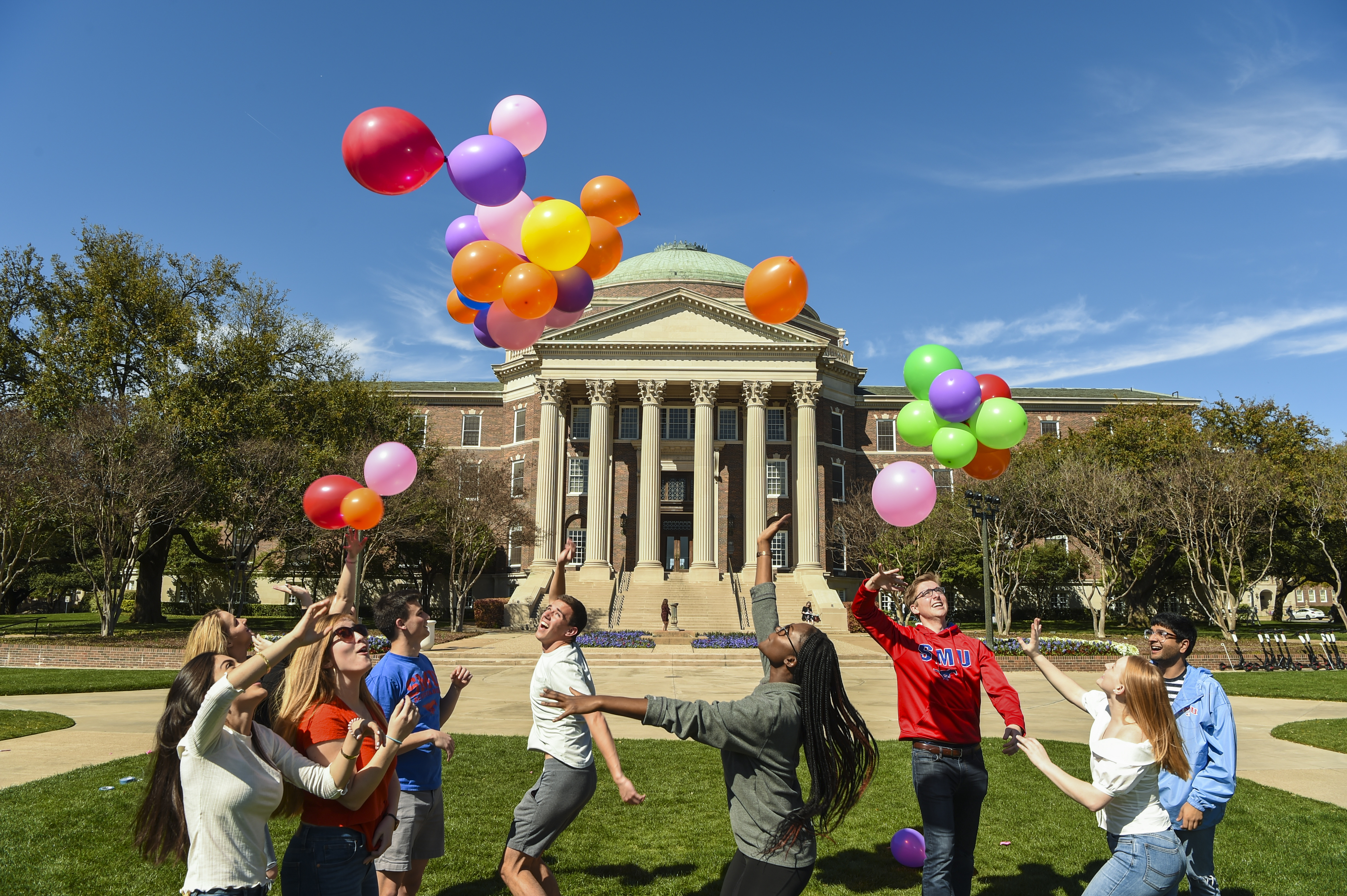 Students on Dallas Hall Lawn chasing balloons