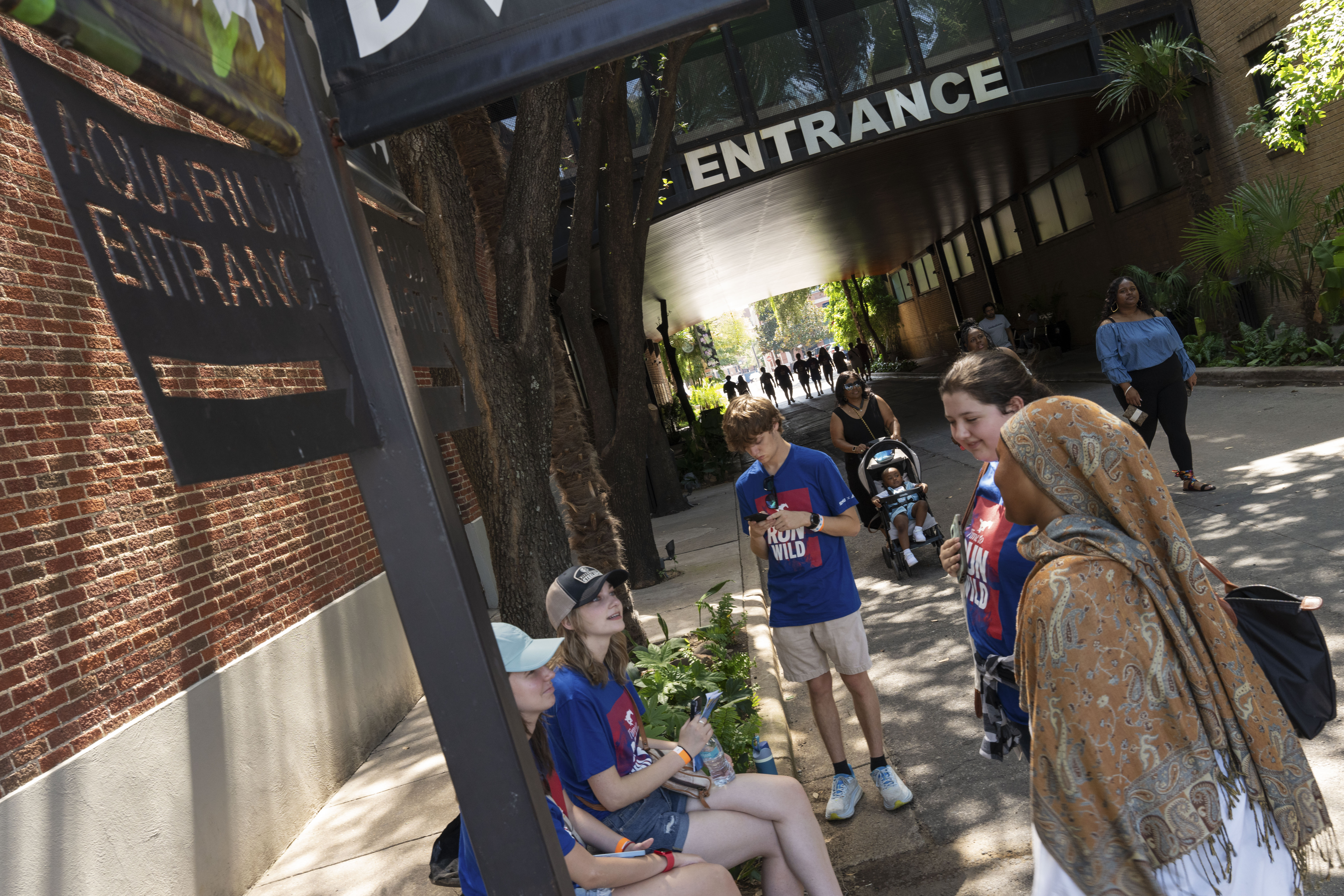 Students gathered outside a gate labeled "Entrance"