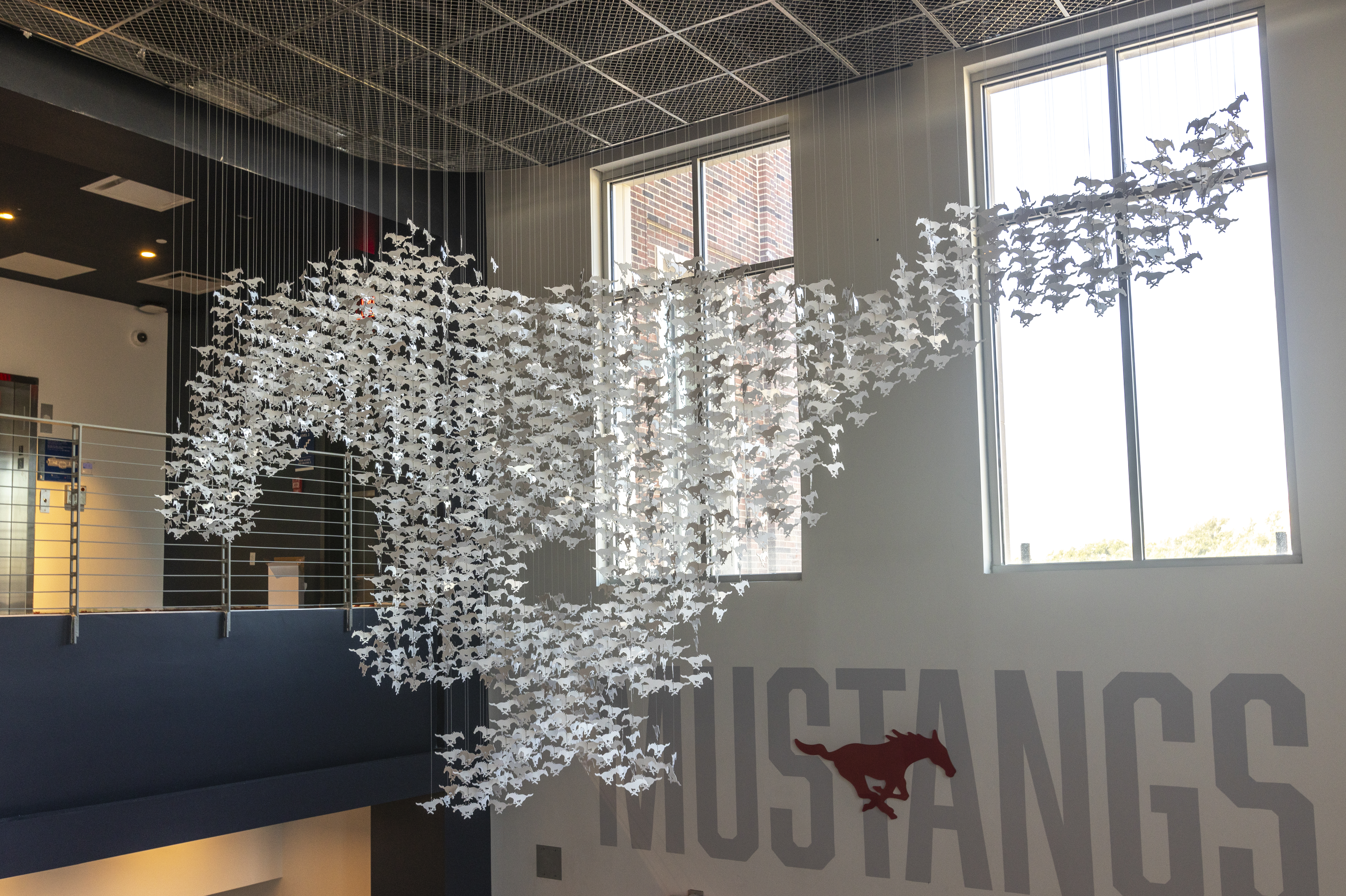 Art installation, small white paper Perunas suspended on fishing line to construct one large Peruna