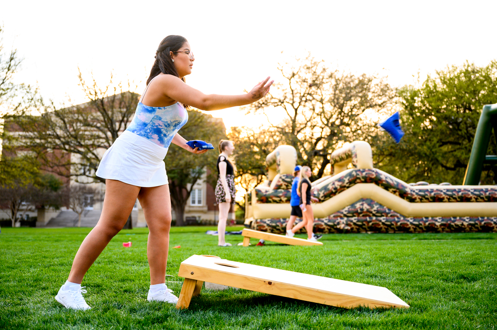 Student at event playing cornhole 