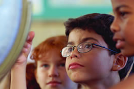 Young students looking at globe