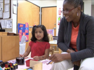 Teacher and student working one-on-one in classroom.