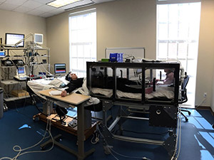 Interior of the Simmons School's Integrative Laboratory with a bed, computers, medical equipment, and monitors.