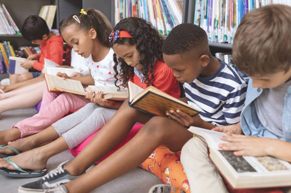 Elementary School Kids Reading Books in Library