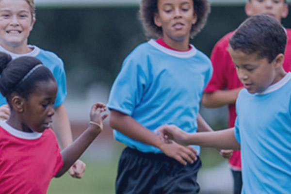 Young children running on soccer field