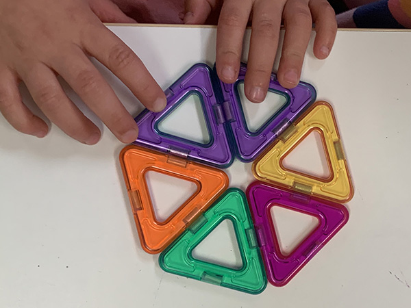 A young student using a manipulative for teaching spatial reasoning.