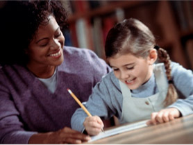 A woman and child write together, using a notebook, at a table.