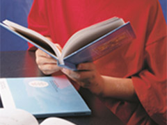 A young student is focused on reading a book.