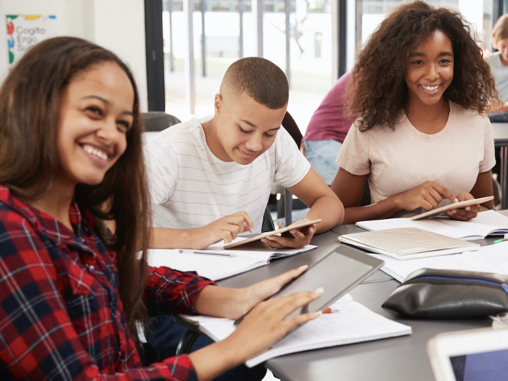 Students working on iPads in a classroom environment.