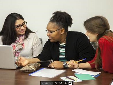 A group of three teachers working and collaborating with one another.