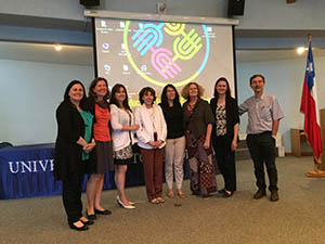 Professor Doris Luft Baker with group of people standing in front of a presentation screen. Image for Project VES: Vocabulario Explícito y Sistemático, a study on Spanish vocabulary intervention for second grade students in Chile.