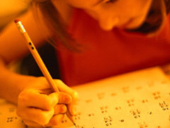 A girl writes on paper with a pencil, engaged in a math activity.
