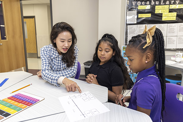 Small-group mathematics instruction showing an educator supporting middle school students with fraction and number line concepts as part of a mathematics learning initiative.