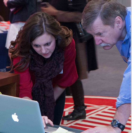 Research participants engaged in discussion while looking at a laptop