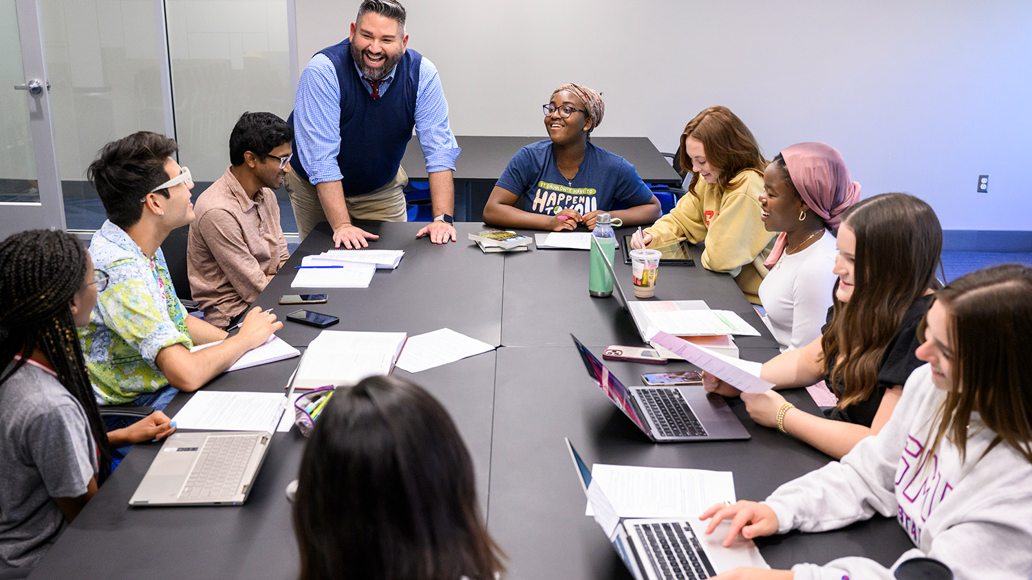 People on laptops working around a large table.