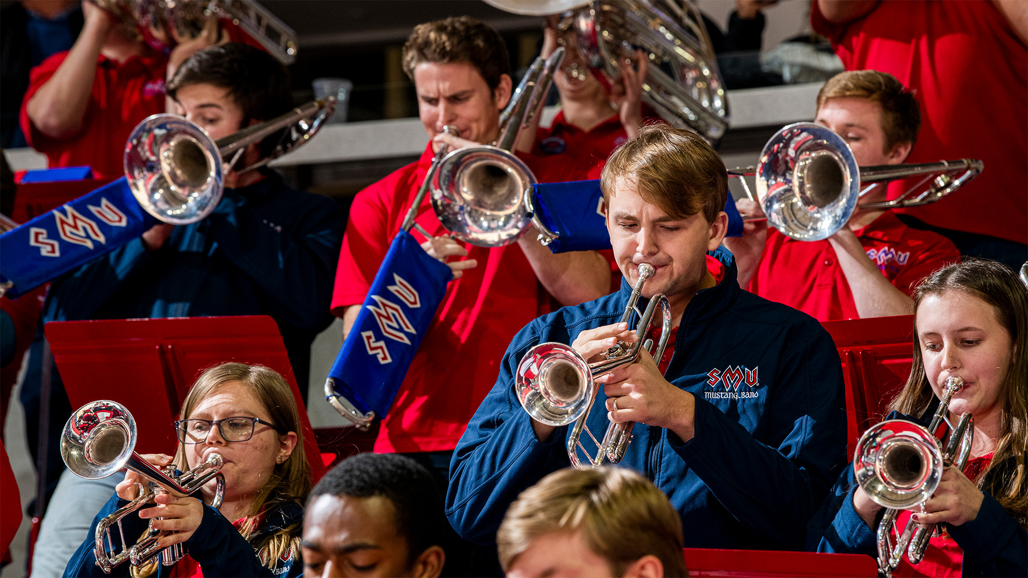 SMU Mustang Band, trumpet players playing in stands at basketball game