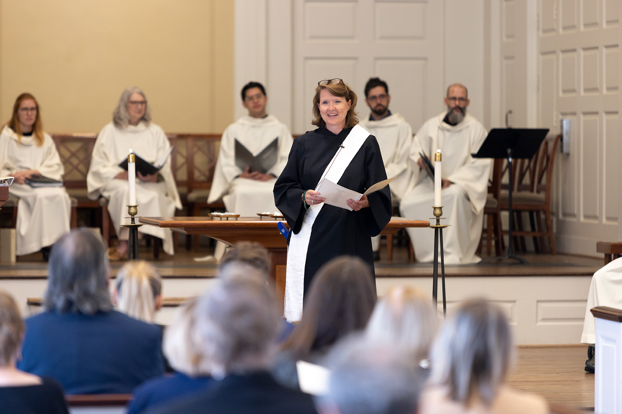 Reverend Lisa Garvin in black robe with white stole giving sermon in Perkins Chapel