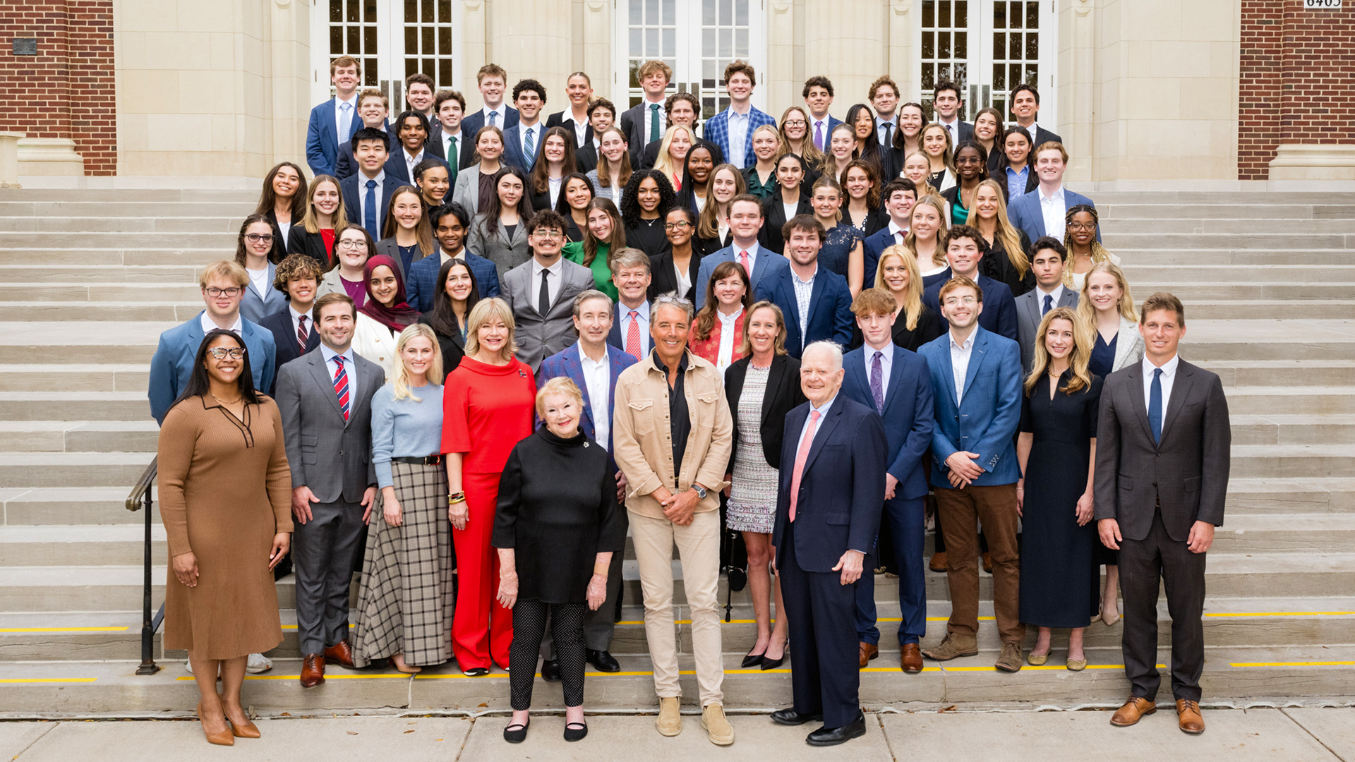 Hunt Scholars with Ray L. and Nancy Ann Hunt and Dan Buettner standing outside in front of McFarlin Auditorium
