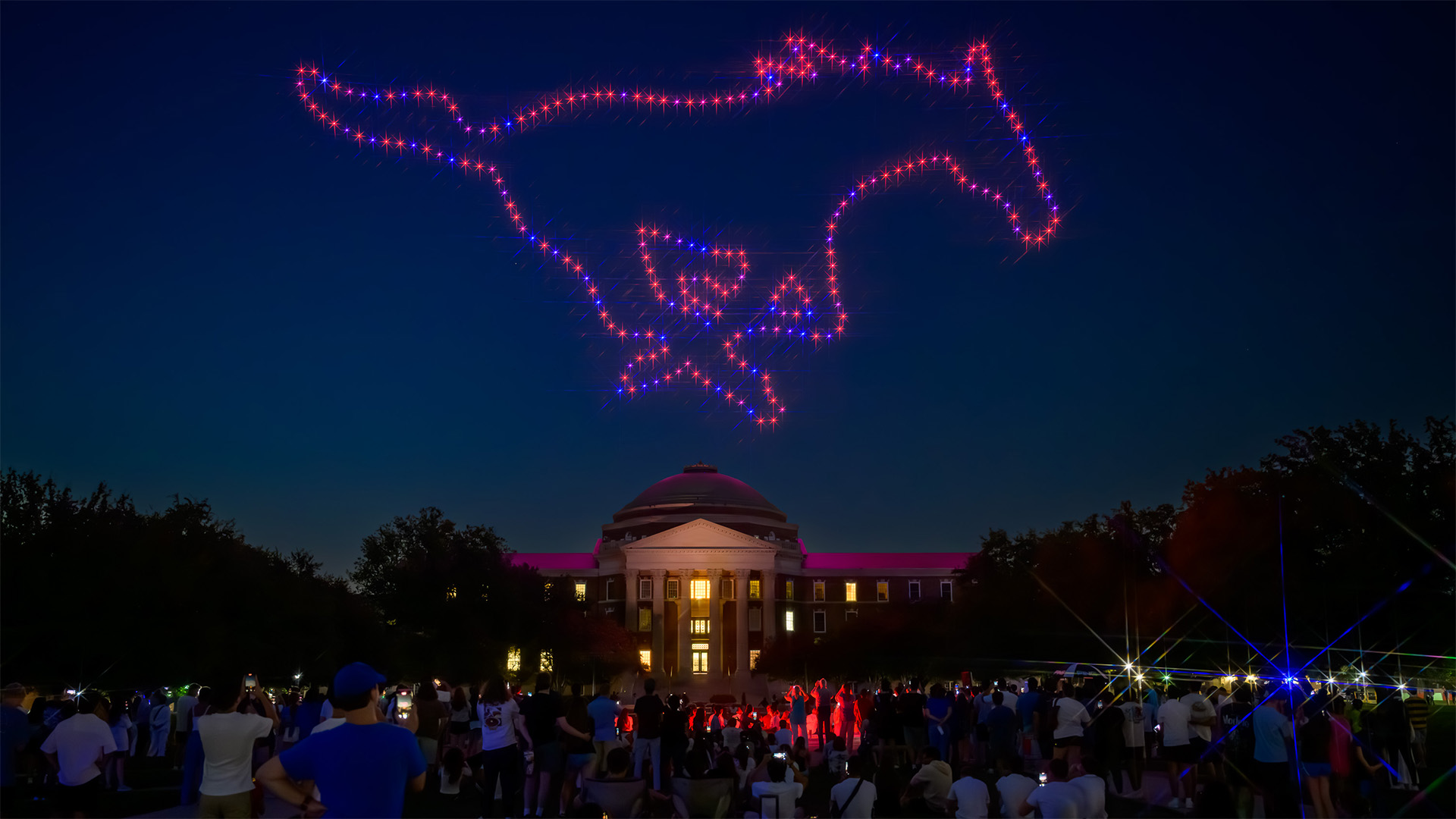 drones forming the shape of a mustang in red and blue above dallas hall