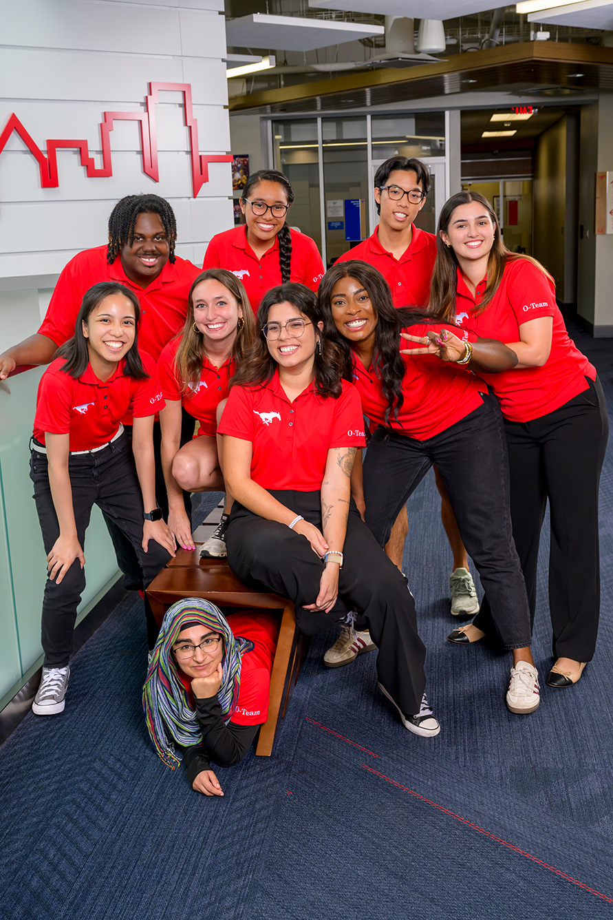 group of students in red shirts and black pants posing for a photo