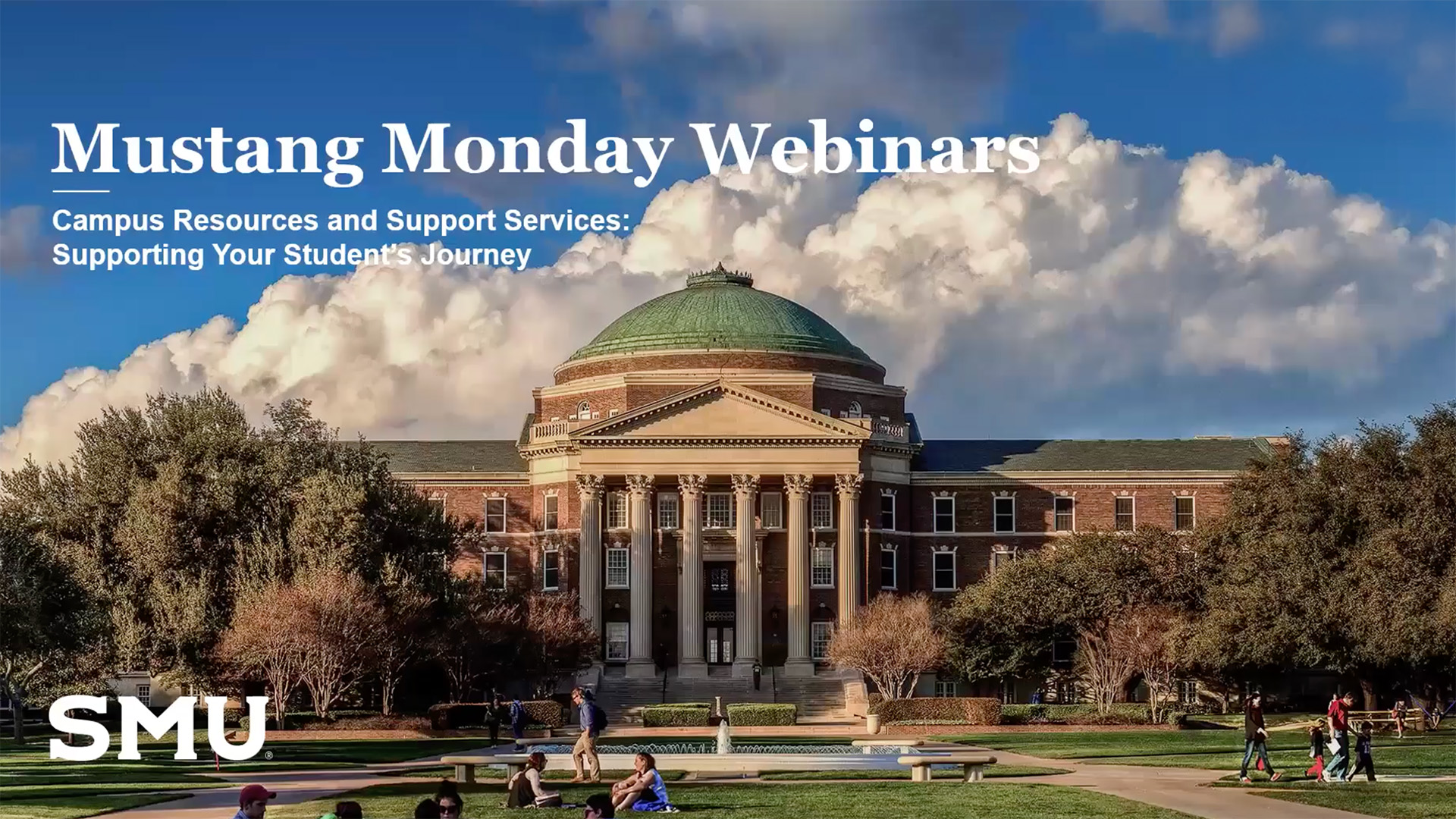 Dallas Hall with blue sky and clouds in the background, trees lining the sides of the building, and people gathered outside on the lawn