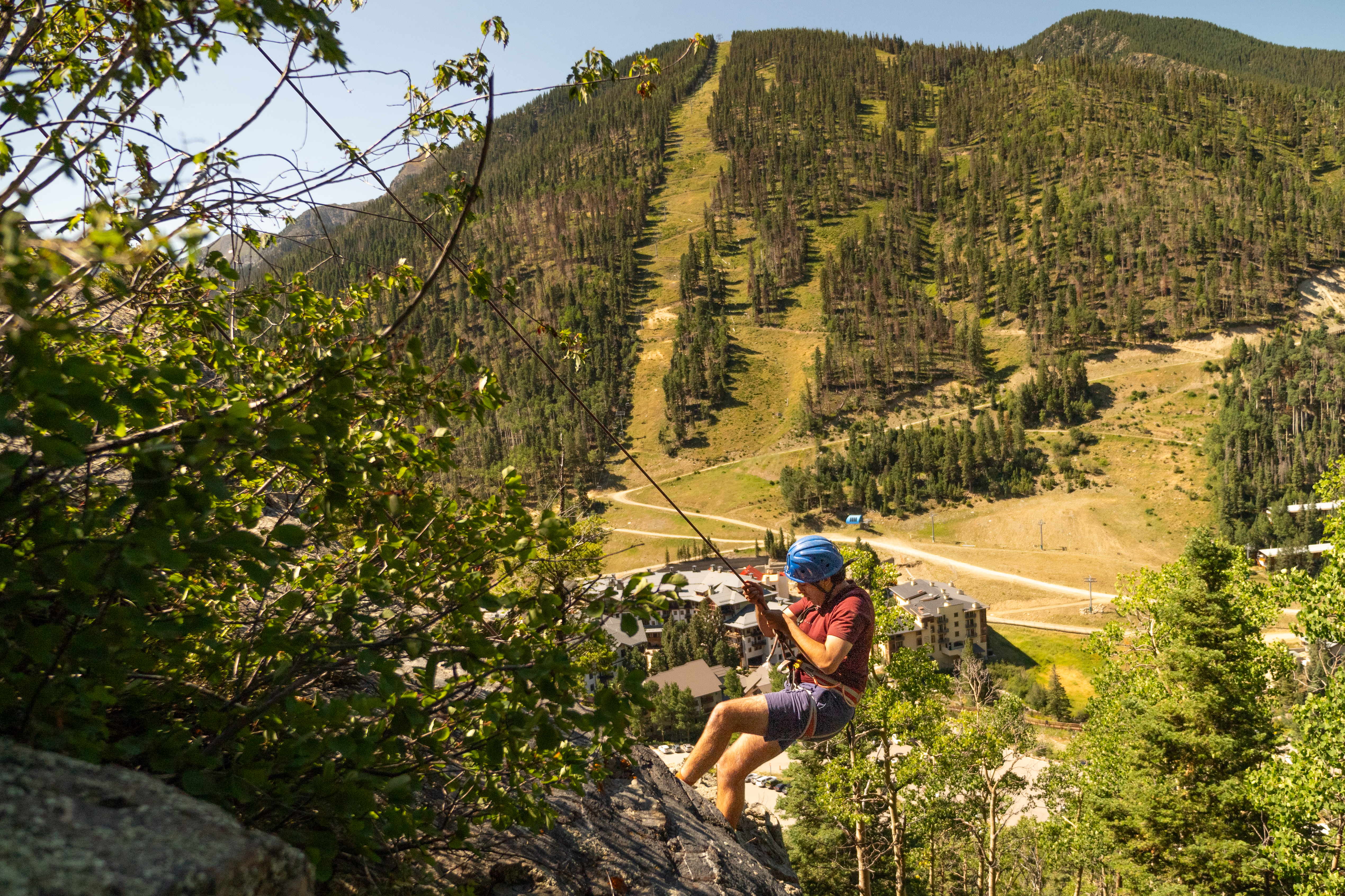 Student Rock Climbing with Mountains in the Background
