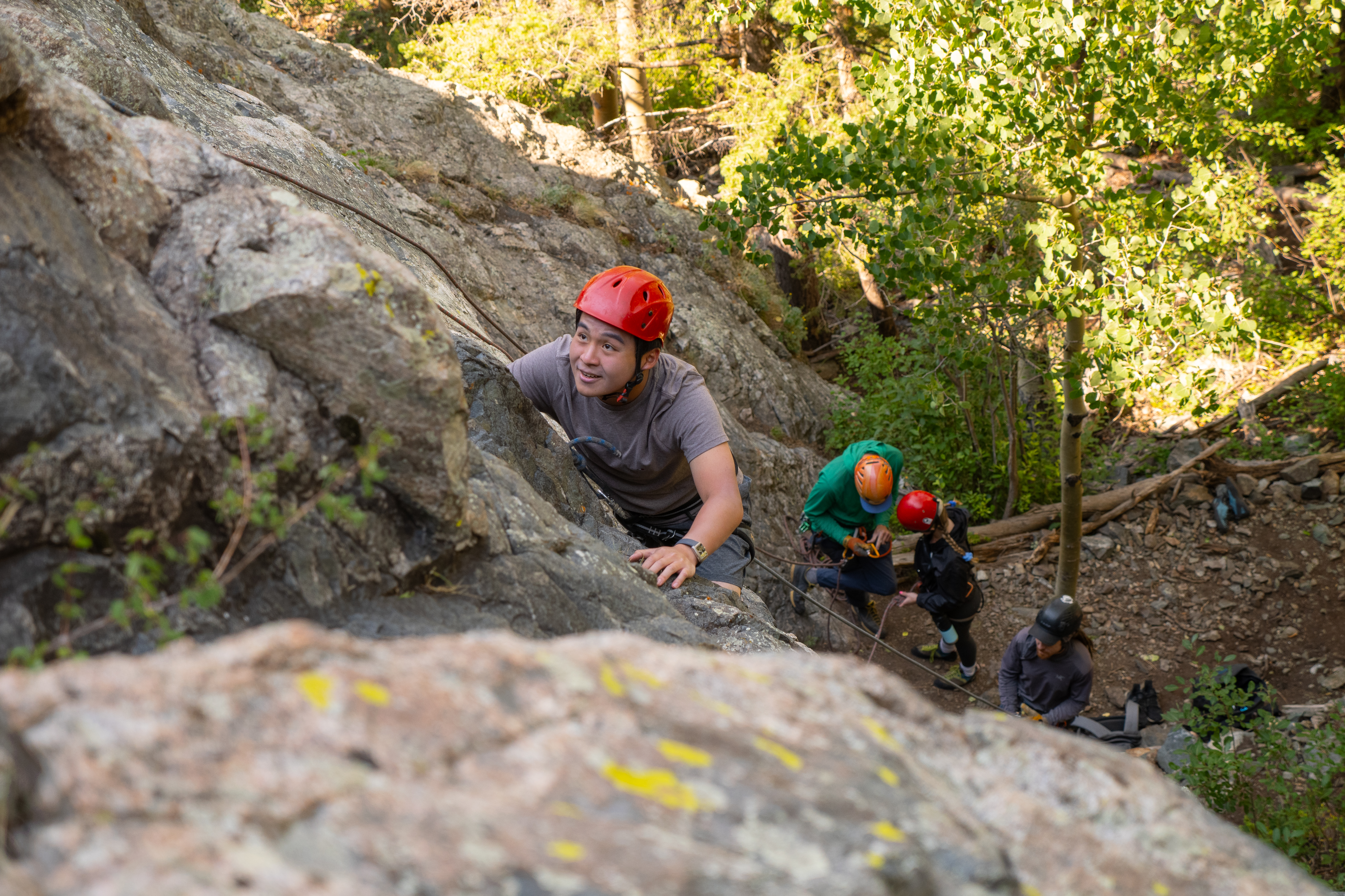Student rock climbing with the camera looking down on them from above.