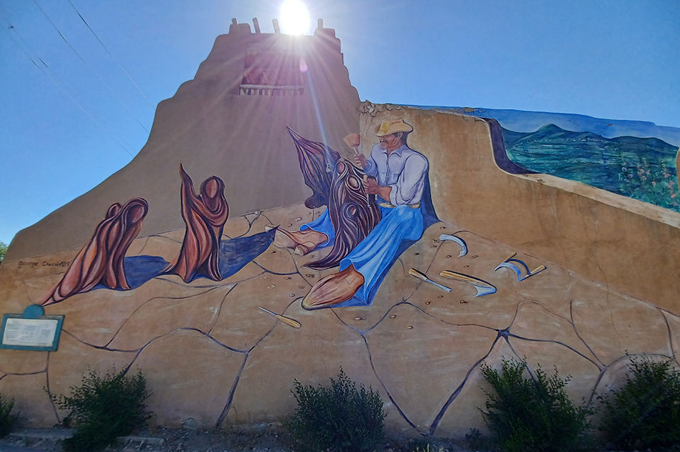 Art on the exterior of a building with the sun shining just above.