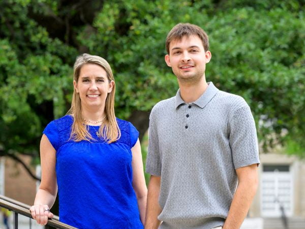Photo of Melissa Escher in blue and her son Jordan in a grey collard shirt standing together on campus