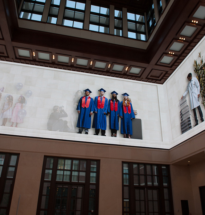 The Bush Center’s Freedom Hall features a 360-degree, high-definition video wall showing images of people at work and play. This image shows four college graduates wearing, not surprisingly, SMU blue and red. 