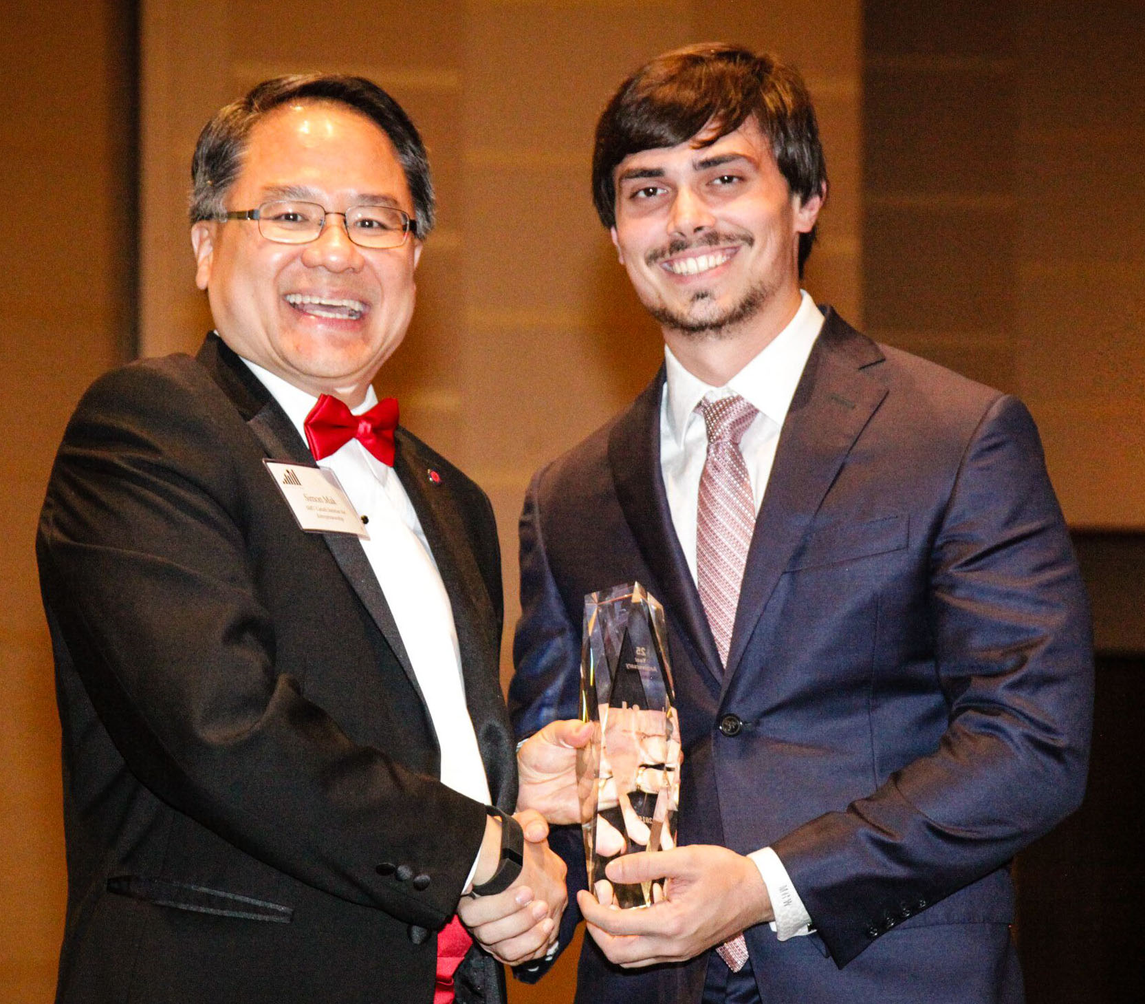 Simon Mak, PhD, associate director of the Caruth Institute for Entrepreneurship, congratulates this year’s Dallas 100 first place winner, JM Bullion CEO Michael Wittmeyer.