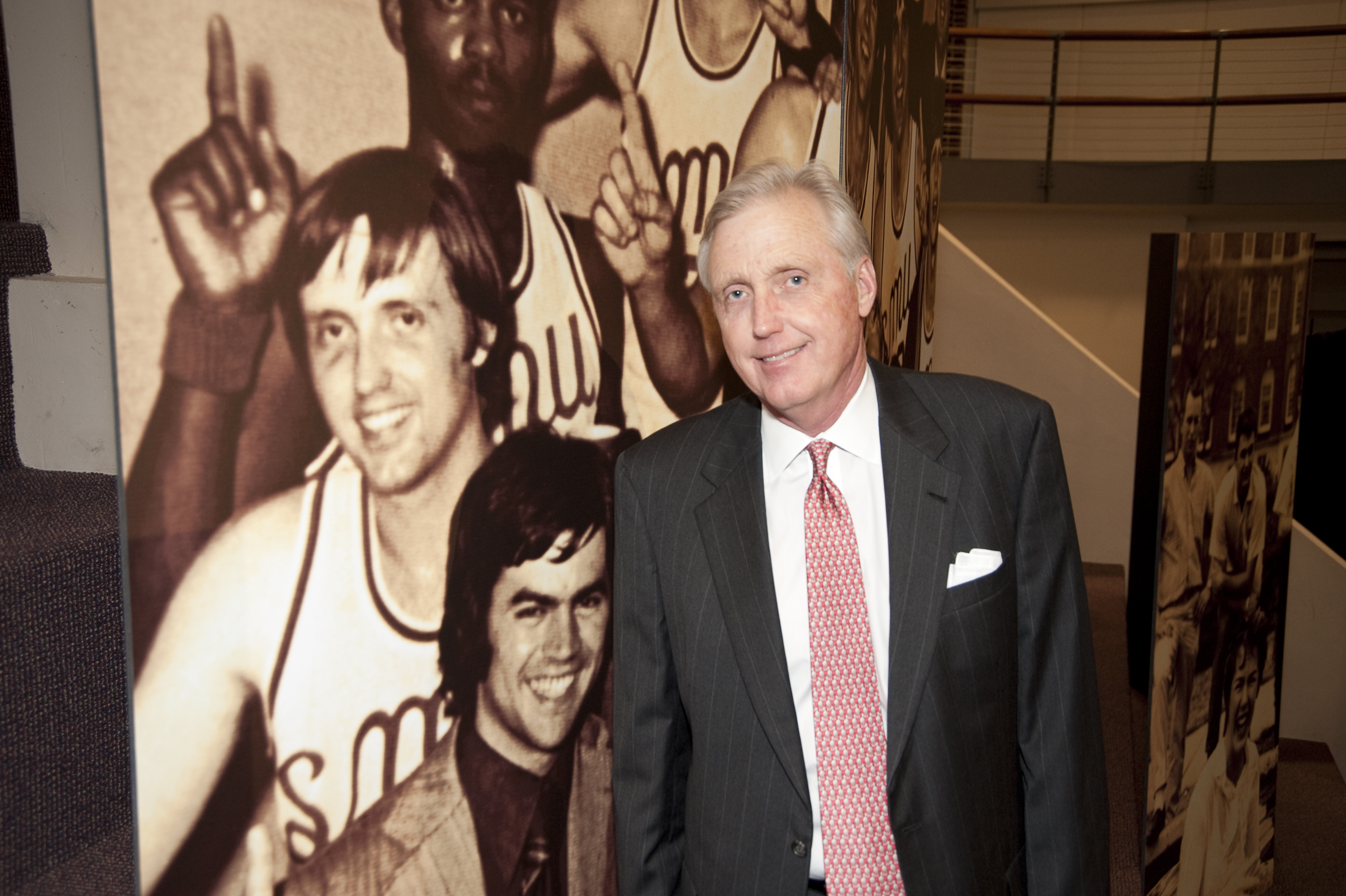 David B. Miller ’72, ’73 stands in front of a photo of his younger self.