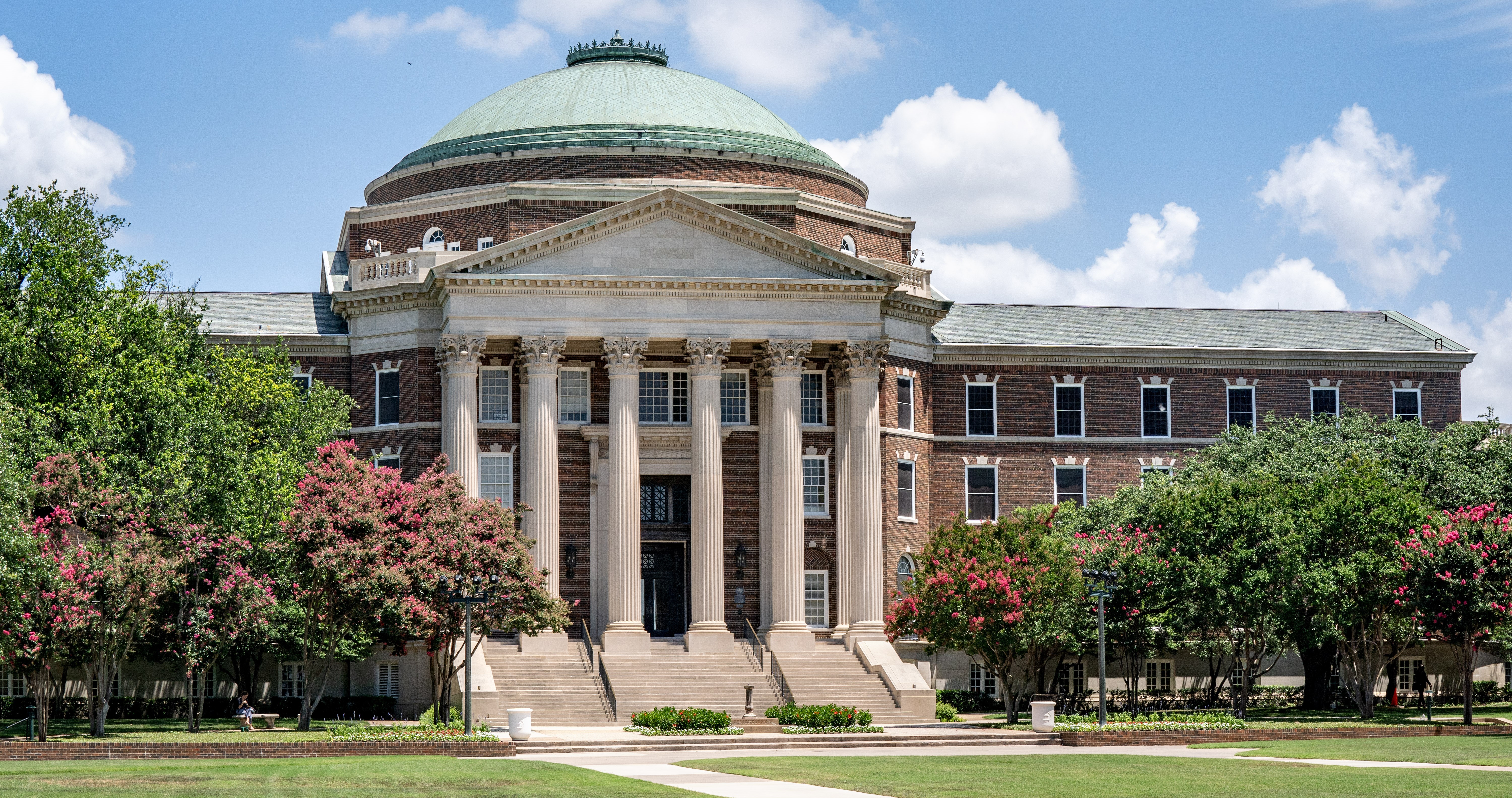The front of Dallas Hall rotunda on a partially cloudy day 